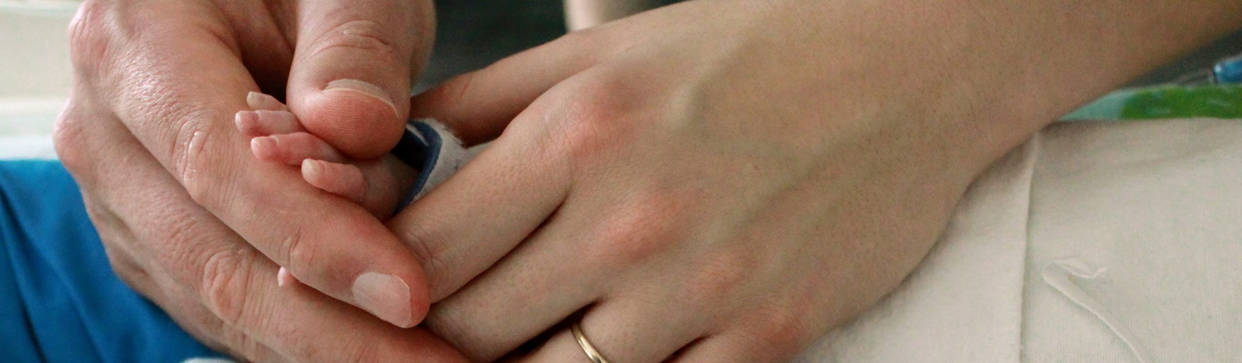 Dani and Darren holding their baby Jack's hands