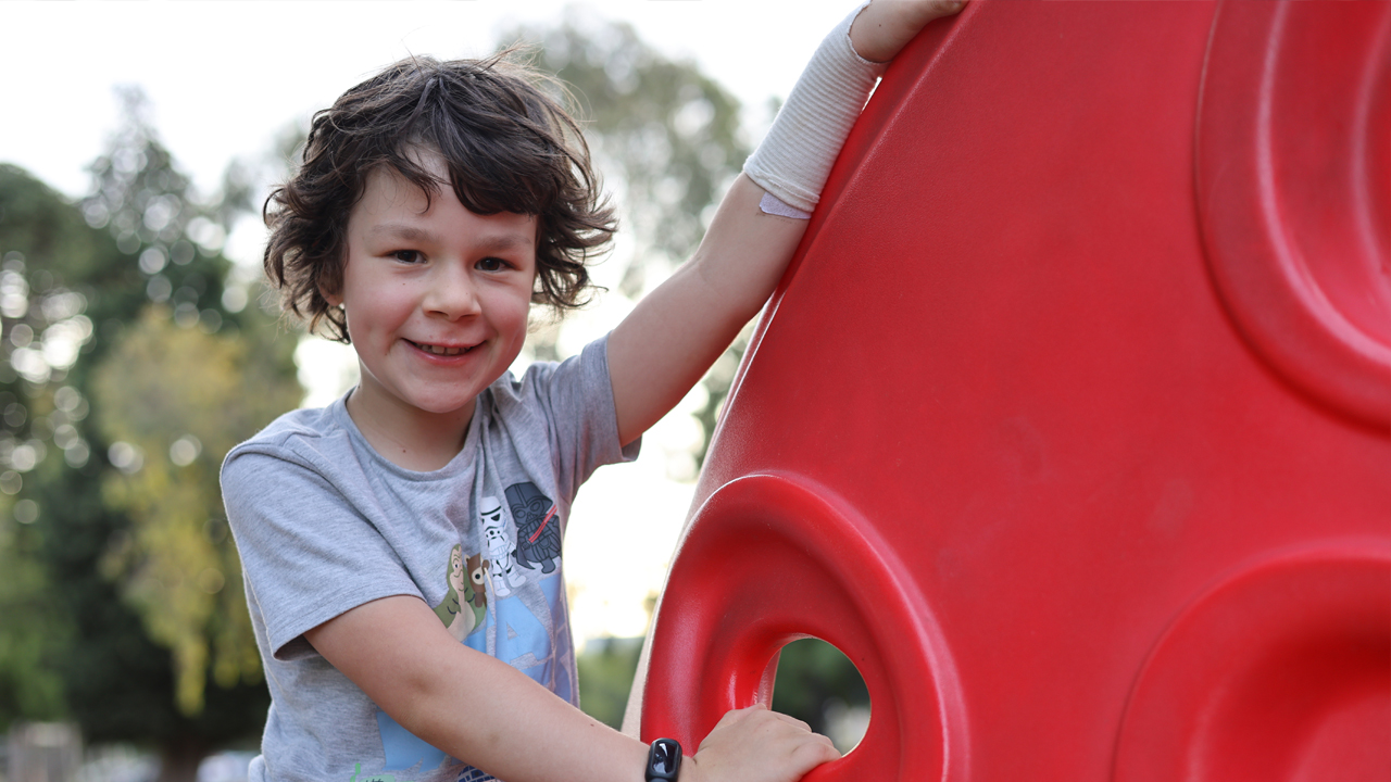 Luca Boggia-Hall rare brain tumor survivor playing in a park and laughing